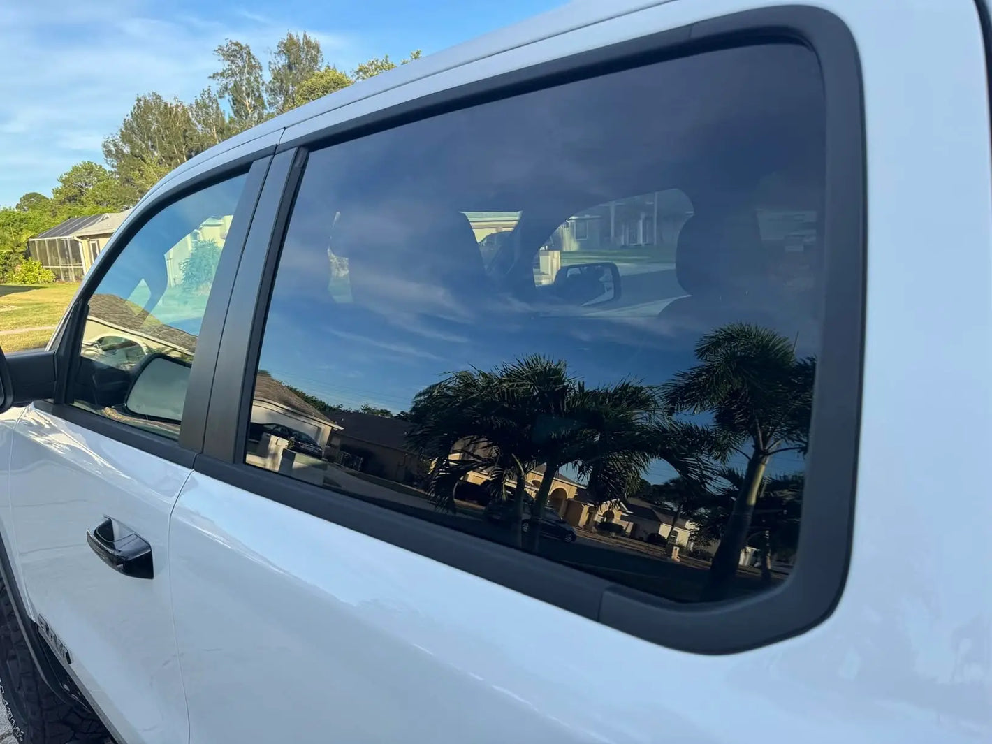 Clean car side window reflecting blue sky and clouds after using Kapak glass cleaner