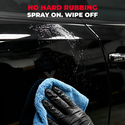 Hand with microfiber towel wiping ceramic spray on black car paint 